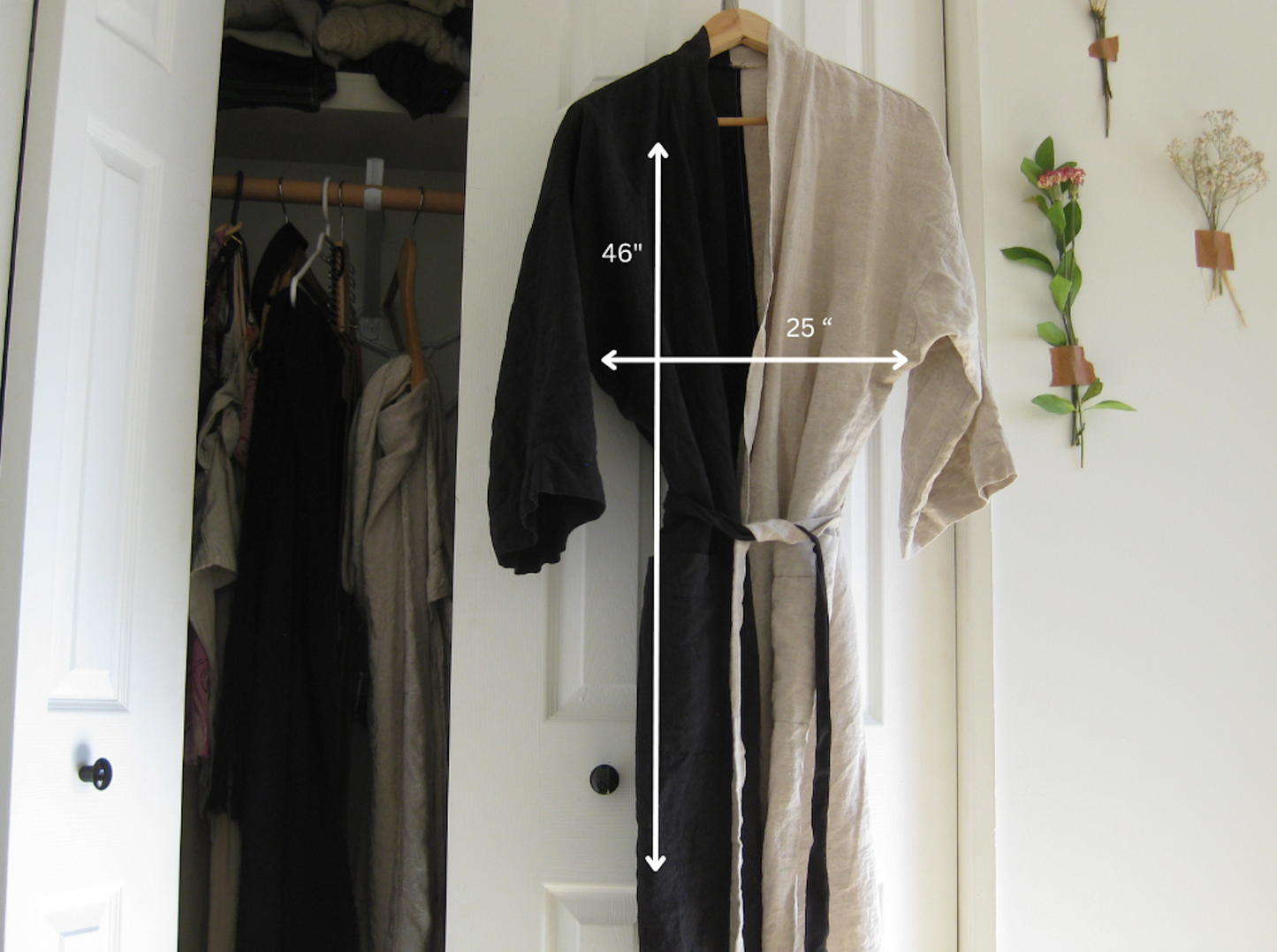 Two robes, one black and one beige, hanging on a rack with measurements indicated.